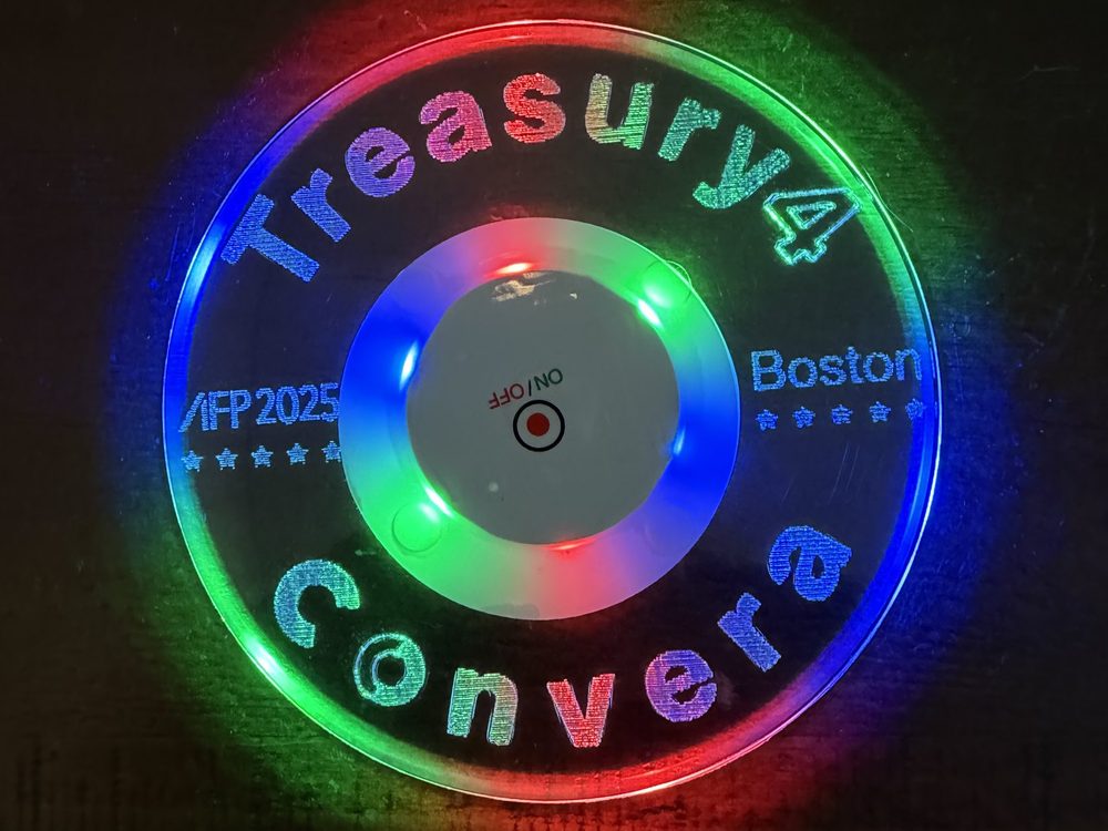 A round engraved acrylic panel lit in multiple colours, marking a conference in Boston