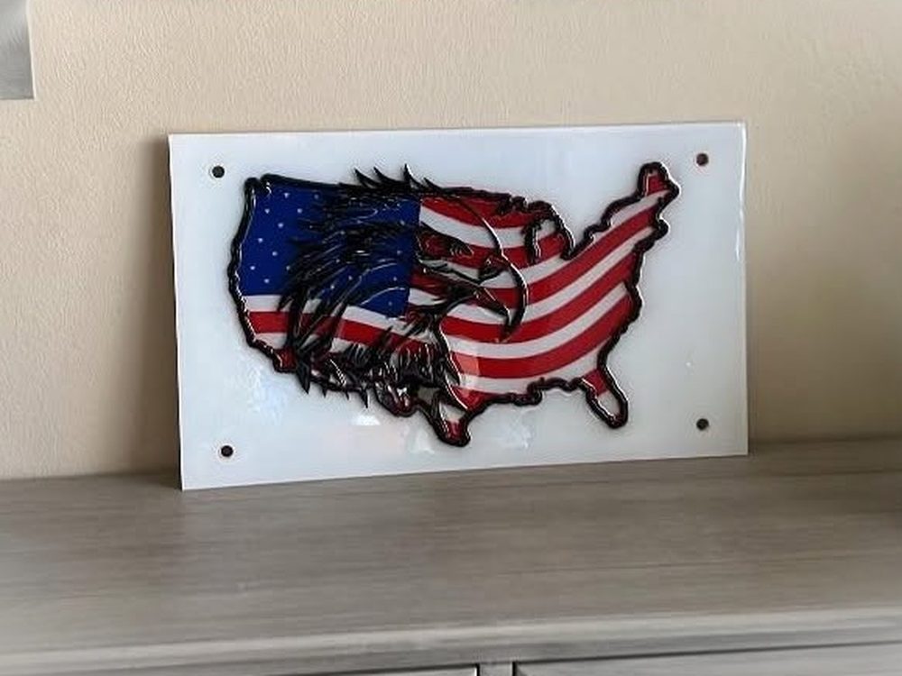 Wall art of the United States filled with an eagle and the American flag, mounted on white acrylic