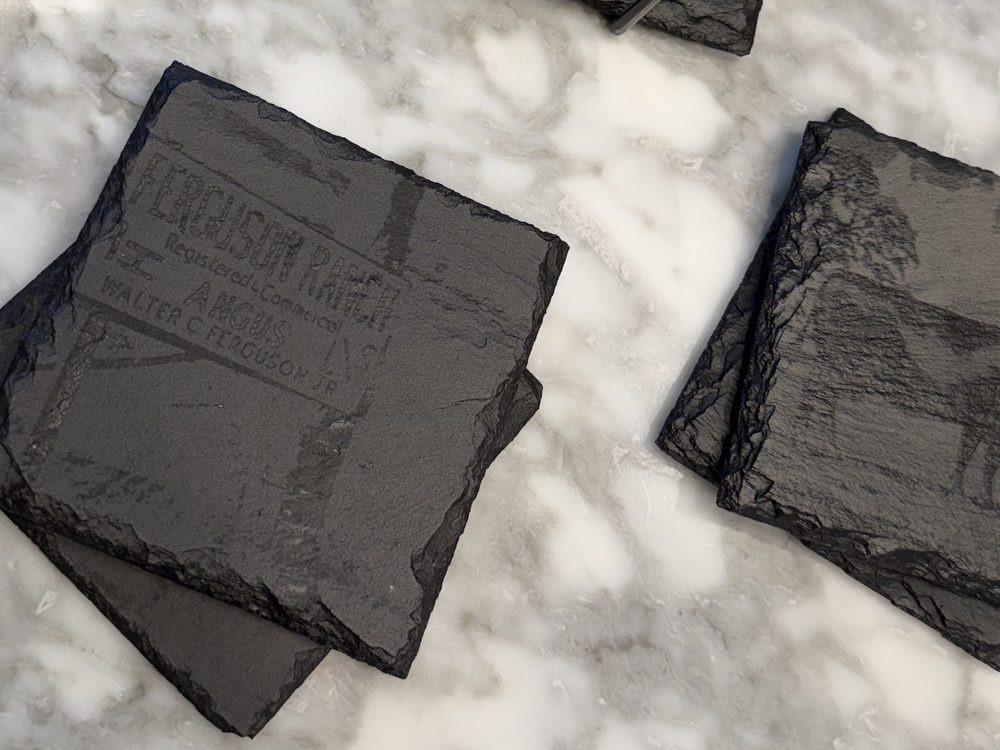 Slate coasters engraved with a cattle ranch brand and herd artwork