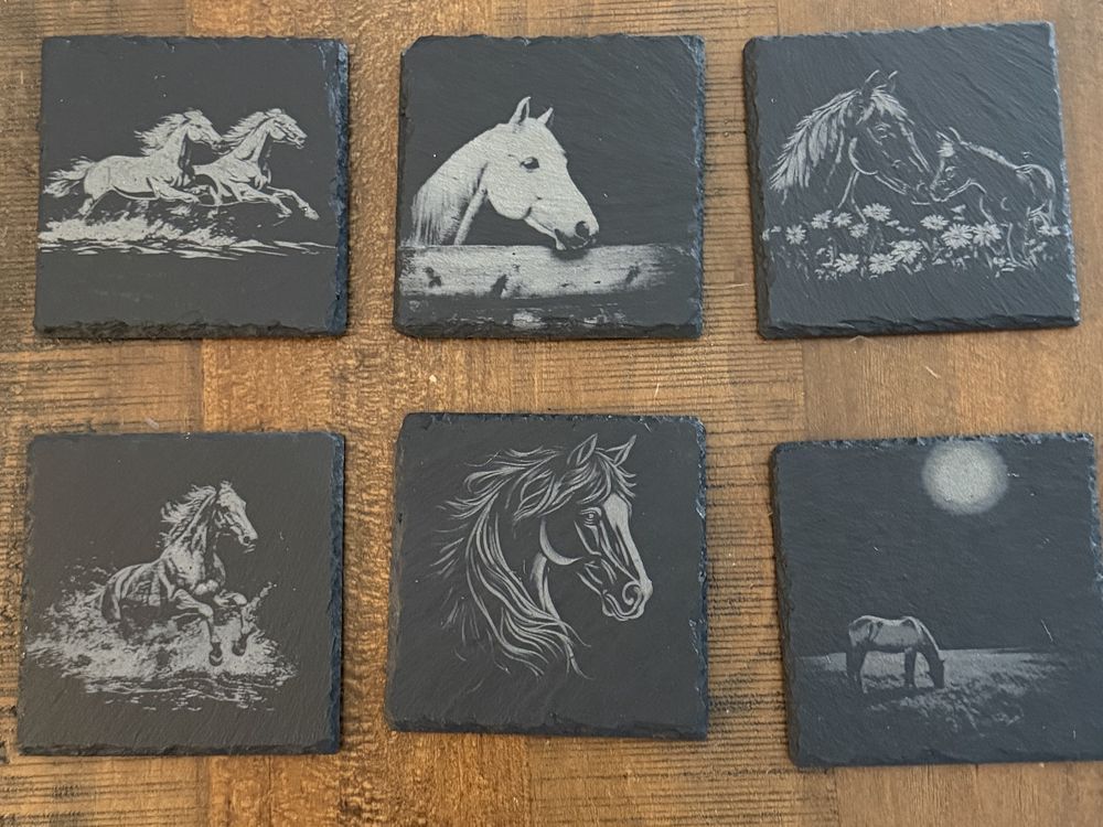 A set of laser-engraved slate coasters in matching designs